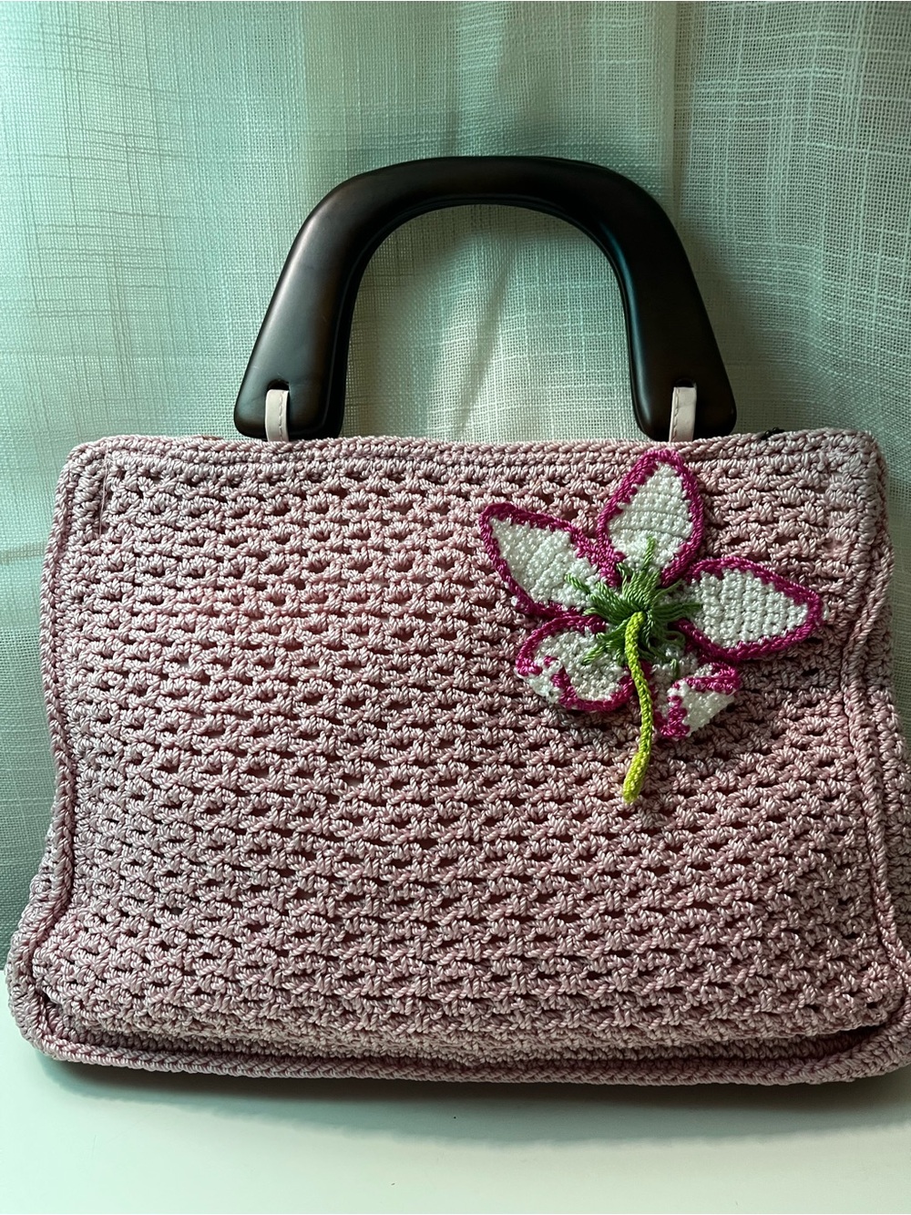 The SAK Pink Crochet Tote Bag with Brown Wooden Handles and Flower Appliqué